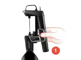 Black handheld kitchen tool with a lever, illustrating step one of use, showing a hand gripping the handle.