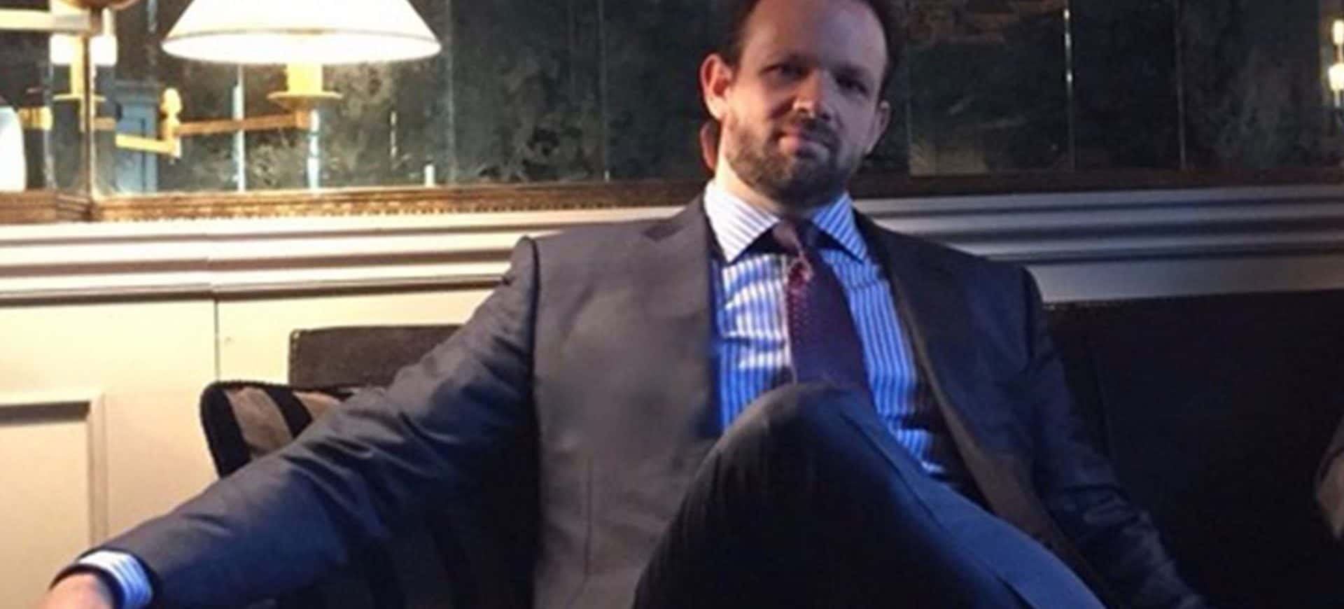 Ben Aneff, Managing Partner of Tribeca Wine Merchants, seated in a suit during an interview in a sophisticated lounge setting.