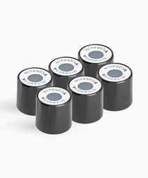 Six black Coravin capsules stacked, each featuring a round white top with the Coravin logo and a colored dot in the center.